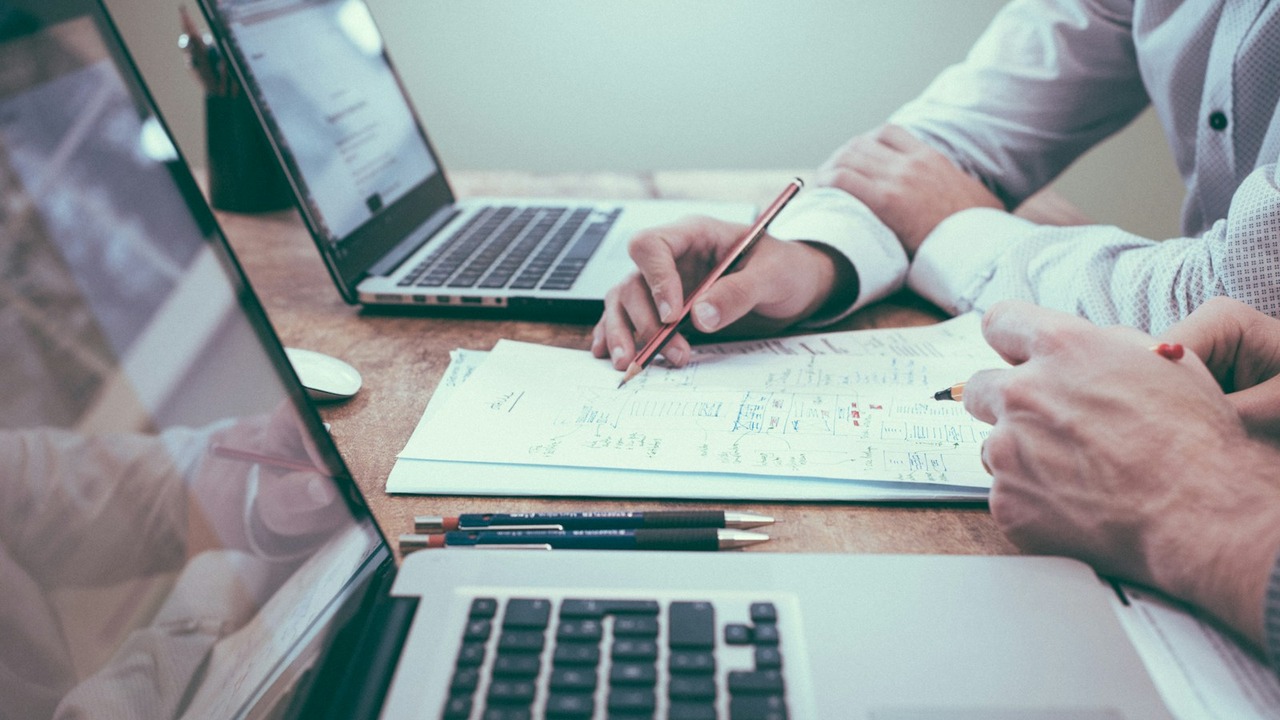 Financial consultation reviewing loan paperwork and debt-to-income calculations
