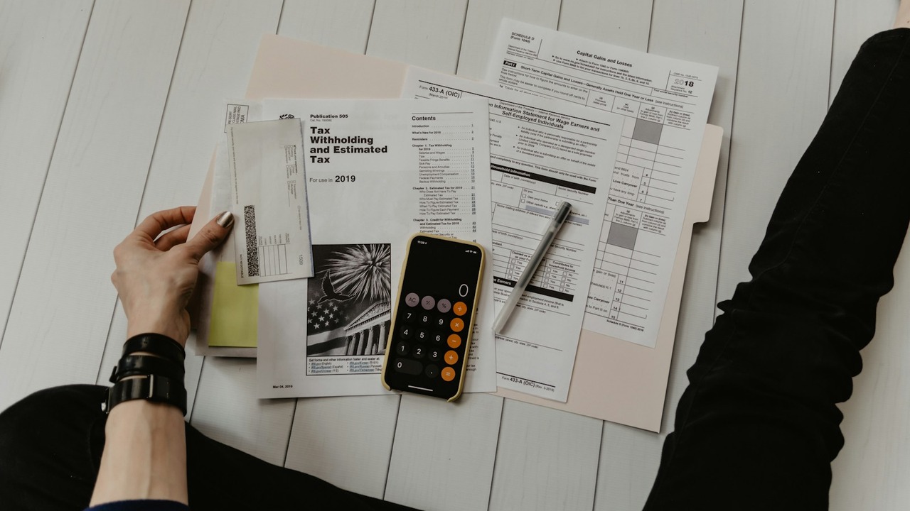 Tax assessment documents, tax computation forms, and calculator on office desk